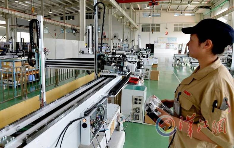 中日龙(襄阳)机电技术开发公司员工对即将出厂的工业自动化机械手进行